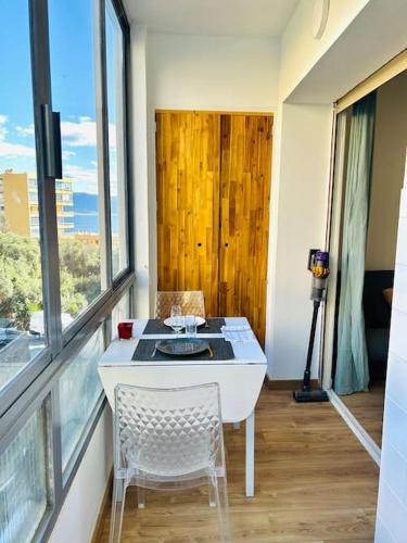 une pièce avec une table, des chaises et une fenêtre dans l'établissement Charmant studio Sanguinaires, à Ajaccio