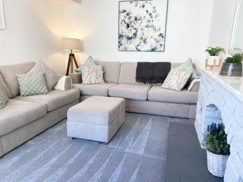 ein Wohnzimmer mit Couch und Kamin in der Unterkunft Modern 4-bed Cottage Llanwrst Town Centre & Parking - Snowdonia! near Betws-y-Coed in Llanrwst