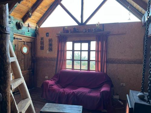 een woonkamer met een bank en een raam bij Ma-hai in Ushuaia