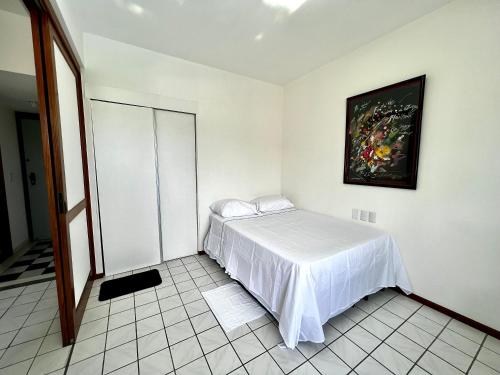 1 dormitorio con 1 cama y una pintura en la pared en Apto completo na orla da Pituba!, en Salvador
