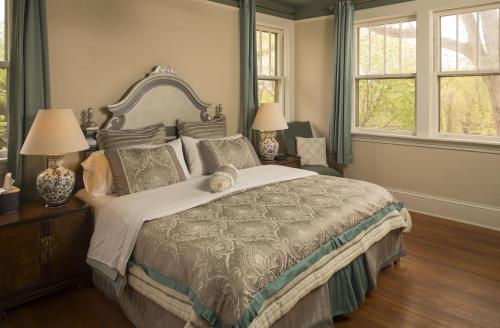 a bedroom with a large bed and two windows at Sweet Biscuit Inn in Asheville