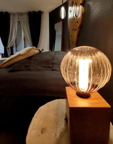 a lamp on a table next to a bed at Groom Épernay - Le Petit Tonnelier in Épernay