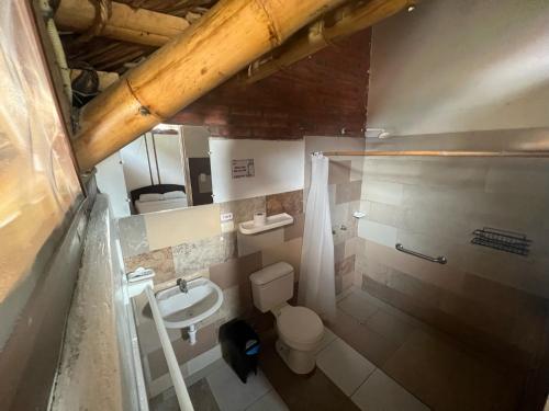 a small bathroom with a toilet and a sink at Zutalu - Playa Sur in Puerto López