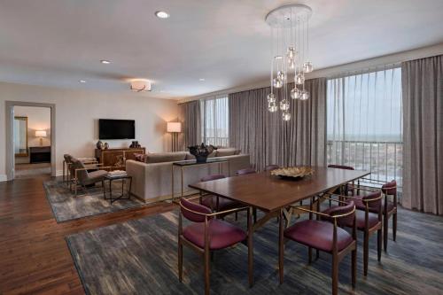 a dining room and living room with a table and chairs at The Westin Galleria Houston in Houston