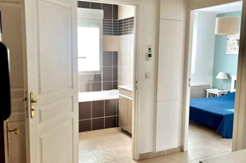 une chambre avec un lit et une salle de bain avec baignoire dans l'établissement E41 La Ferme de Deauville 1 ch. SOZEN C., à Saint-Arnoult