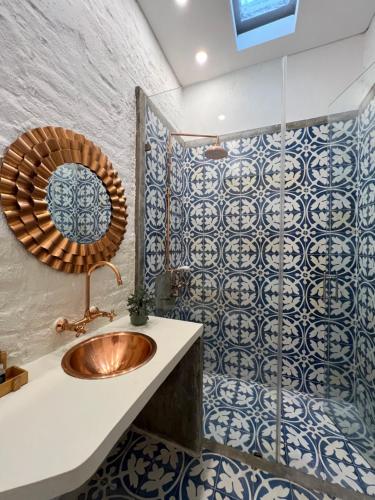 uma casa de banho com lavatório e azulejos azuis e brancos em MAHI CASA BOUTIQUE em Cali