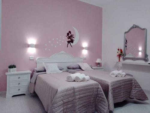 1 dormitorio con 1 cama con 2 toallas en La vie en rose, en Mola di Bari
