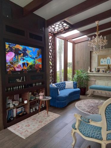 sala de estar con sofá azul y TV en Casa Paraiso, en Guayaquil