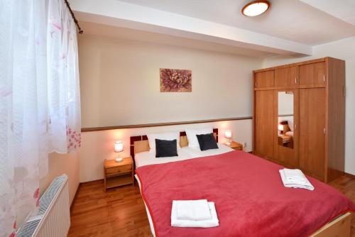 a bedroom with a large red bed in a room at Penzión Víchrica in Veľká Lomnica