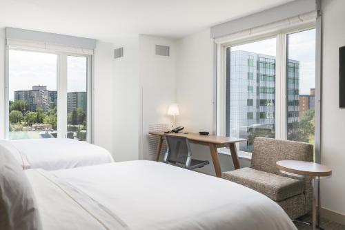 a hotel room with two beds and a desk and a window at Element Denver Downtown East in Denver