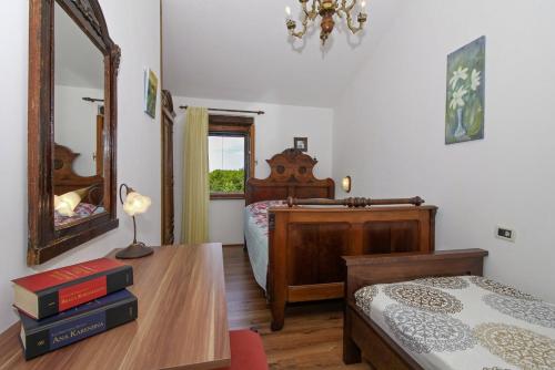 a bedroom with a bed and a table with a mirror at Marija-Lorena in Gora Glušići (Haus für 4-5 Personen) in Labin