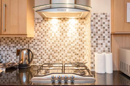 a kitchen with a stove top oven in a kitchen at London Serviced Apartments in London