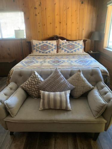 a couch with pillows sitting in front of a bed at The Tamarack Lodge in Lakeshore
