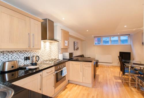 a kitchen with white cabinets and a counter top at London Serviced Apartments in London