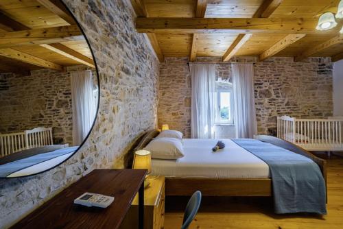 sypialnia z dużym łóżkiem i lustrem w obiekcie Kutić in Štokovci (Haus für 10-15 Personen) w mieście Svetvinčenat