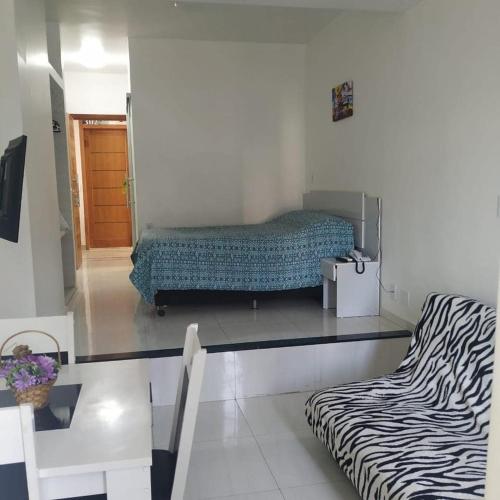 Habitación con cama y sofá con estampado de cebra. en Bahia Flat localização excelente, en Salvador