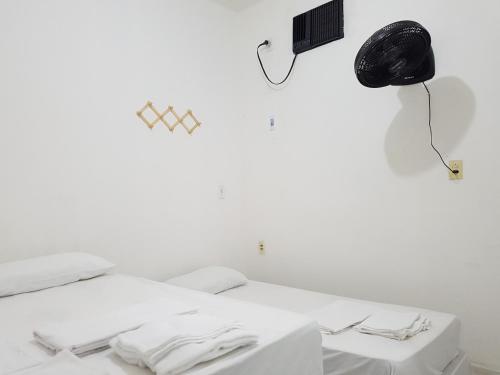 uma cama branca num quarto branco com um candeeiro em Casa Brisa em Fortaleza