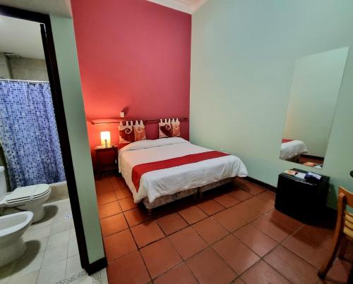 1 dormitorio con 1 cama y baño con aseo en Refugio del Inca en Salta