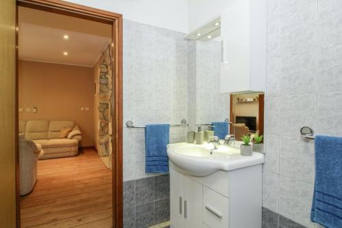 een badkamer met een witte wastafel en een douche bij Dea in Kmeti (Haus für 6 Personen) in Žminj