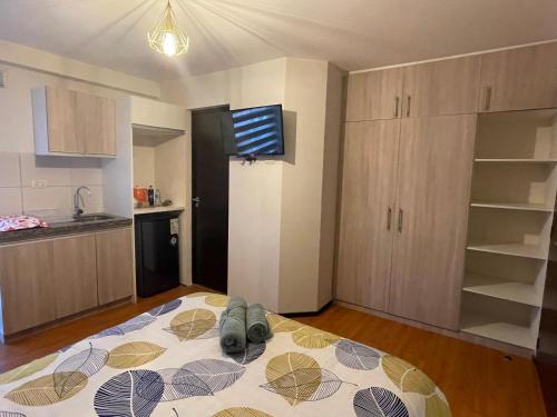 Un dormitorio con una cama con zapatos. en Estudio acogedor y elegante, en Cochabamba