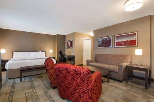 a hotel room with a bed and a couch at Best Western Colonel Butler Inn in Niagara-on-the-Lake