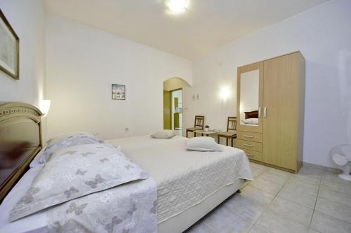 - une chambre avec un lit, une commode et un miroir dans l'établissement Selak in Tučepi - Haus für 6-7 Personen, à Tučepi