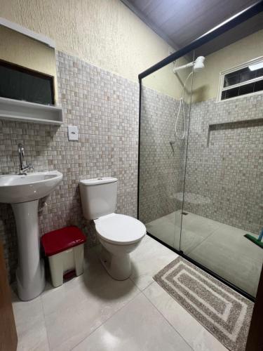 y baño con aseo, lavabo y ducha. en Pousada Catraca, en Pirenópolis