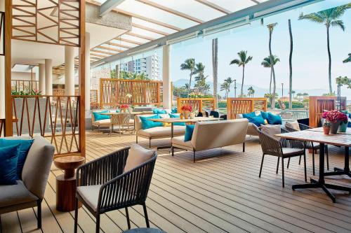 a patio with tables and chairs and palm trees at Marriott Puerto Vallarta Resort & Spa in Puerto Vallarta