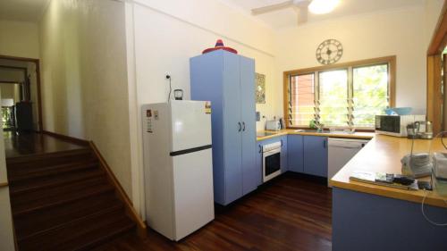 a kitchen with a white refrigerator and blue cabinets at Magnetic Dreams Unit 2 in Arcadia