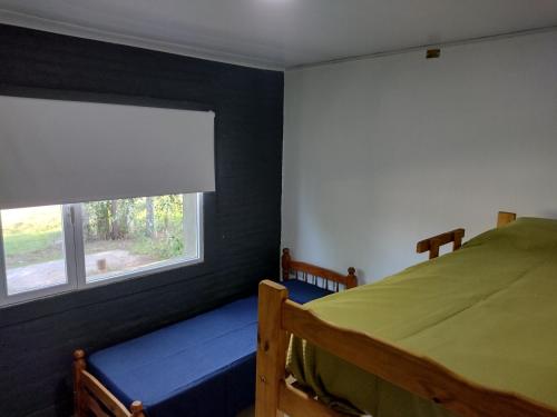 1 dormitorio con cama y ventana en Casa de campo Los Cardenales en Rafaela