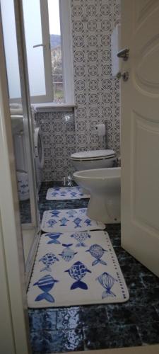 a bathroom with a toilet and blue and white tiles at CASA GIULIA in Levanto