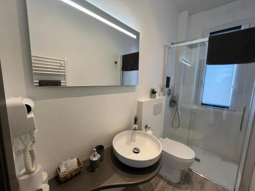 a bathroom with a sink and a toilet and a mirror at Appartamenti Mar y Sol in Gabicce Mare
