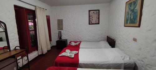 a bedroom with two beds with red and white sheets at Finca Campestre Rancho Alegre in Fusagasuga