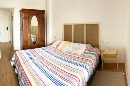 a bedroom with a large bed with a colorful blanket at Apartamento céntrico in Montevideo