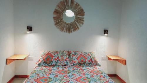 1 dormitorio con cama y espejo en la pared en DON BAUTISTA en Santa Rosa de Calamuchita