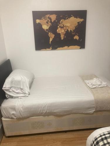 a bedroom with a bed with a map on the wall at 3 Bed Sea View Apartment @ 10B George Street in Ryde