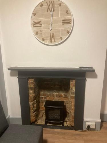 a clock on a wall above a fireplace at 3 Bed Sea View Apartment @ 10B George Street in Ryde