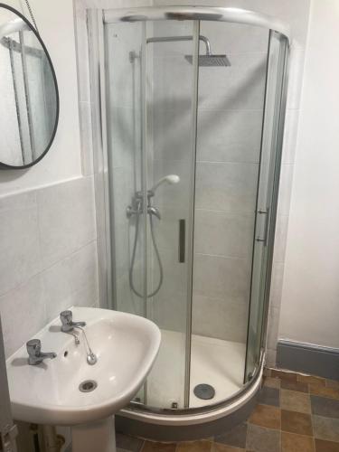 y baño con ducha y lavamanos. en 3 Bed Sea View Apartment @ 10B George Street en Ryde