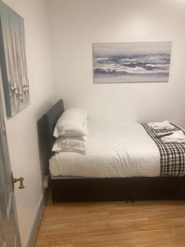 1 dormitorio con 1 cama con sábanas y almohadas blancas en 3 Bed Sea View Apartment @ 10B George Street en Ryde