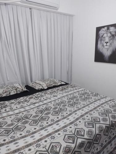 1 dormitorio con 1 cama con una foto de león en la pared en Apt inteiro 1 minuto da praia, en Río de Janeiro