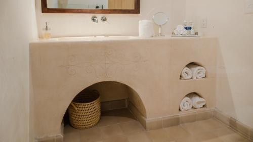 Los Murmullos Casa Boutique por chef Patrick Cros, Campeche في كامبيش: حمام مع حوض ومدفأة