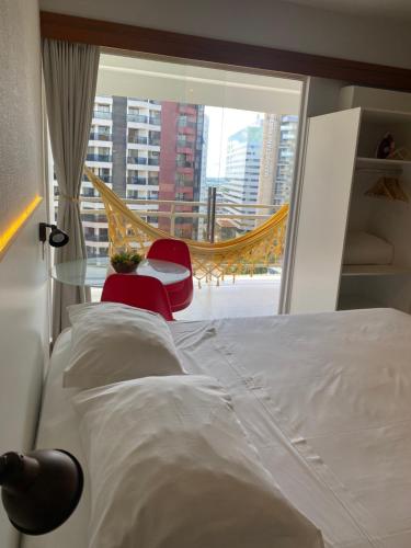 a bedroom with a bed and a window with a hammock at Garvey Park Hotel in Brasilia