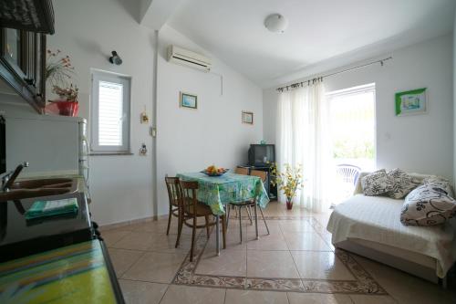 a living room with a table and a couch at Apartments for families with children Novalja, Pag - 6490 in Novalja
