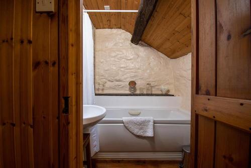 a bathroom with a white tub and a sink at Glan Lledr in Betws-y-coed