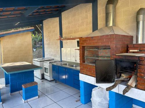 uma grande cozinha com um grande forno de tijolos em Chalé Canto da Viola em São Roque