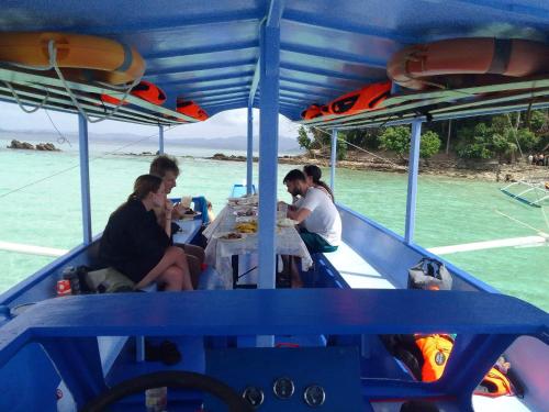 eine Gruppe von Menschen, die an einem Tisch auf einem Boot sitzen in der Unterkunft Ferranco Tourist Inn in San Vicente