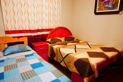 1 dormitorio con 2 camas, mesa y una foto en SUNRISE home, en Ica