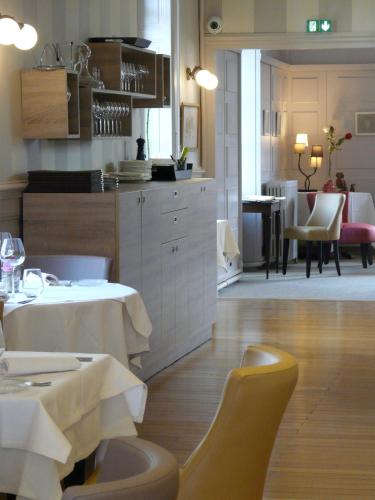 a kitchen and dining room with a table and chairs at Hostellerie d'Héloïse Logis in Cluny