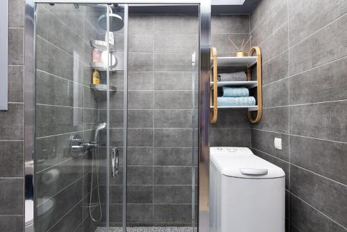 W łazience znajduje się toaleta i przeszklony prysznic. w obiekcie Olympic Mets Apartment w Atenach