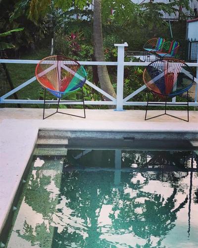 two chairs sitting next to a pool of water at FLOR DE PARAISO BUNGALOWS in Montezuma